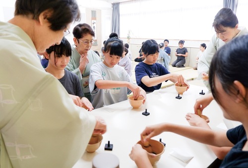 茶の点て方を真剣に学ぶ児童ら