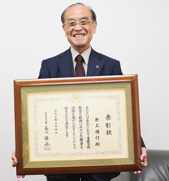贈られた賞状を掲げる井上さん