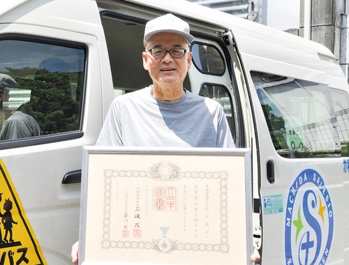 賞状を手に笑顔を見せる長山さん