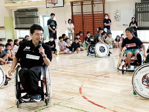 車いすの講師と一緒に、鬼ごっこを楽しむ児童ら (「あすチャレ! ジュニアアカデミー」 主催:日本財団パラスポーツサポートセンター)