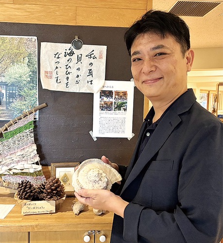 父・謹也さんの思い出の品を手にする齋藤理事長