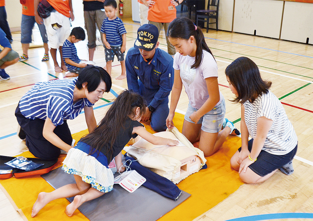 ＡＥＤの使用方法を教わりながら心肺蘇生法を体験する子どもたち
