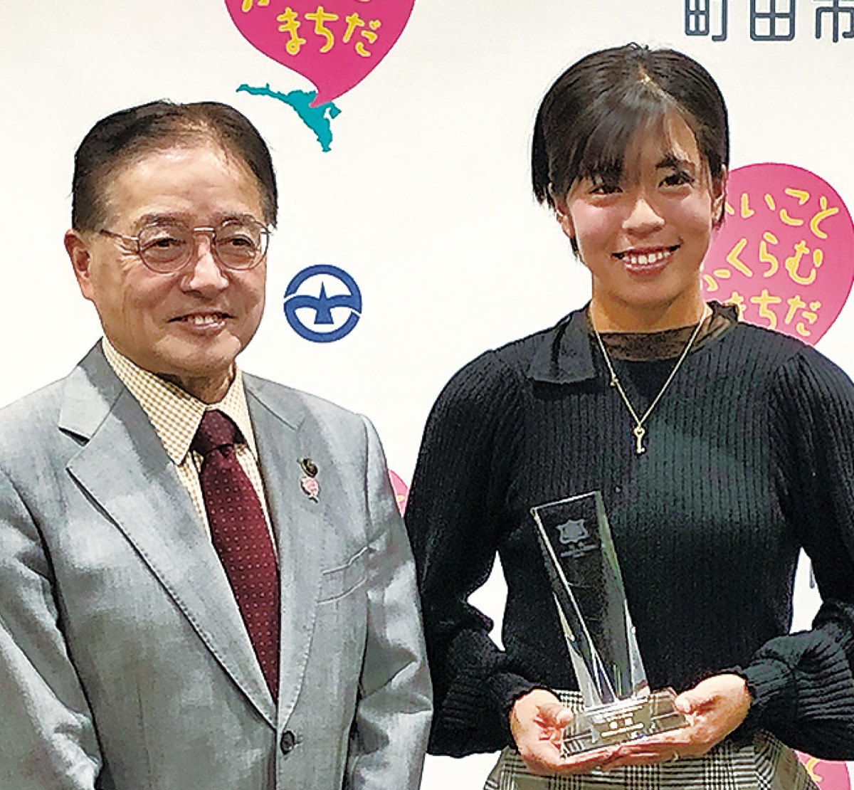 優勝杯を手に笑顔で応える本玉さん