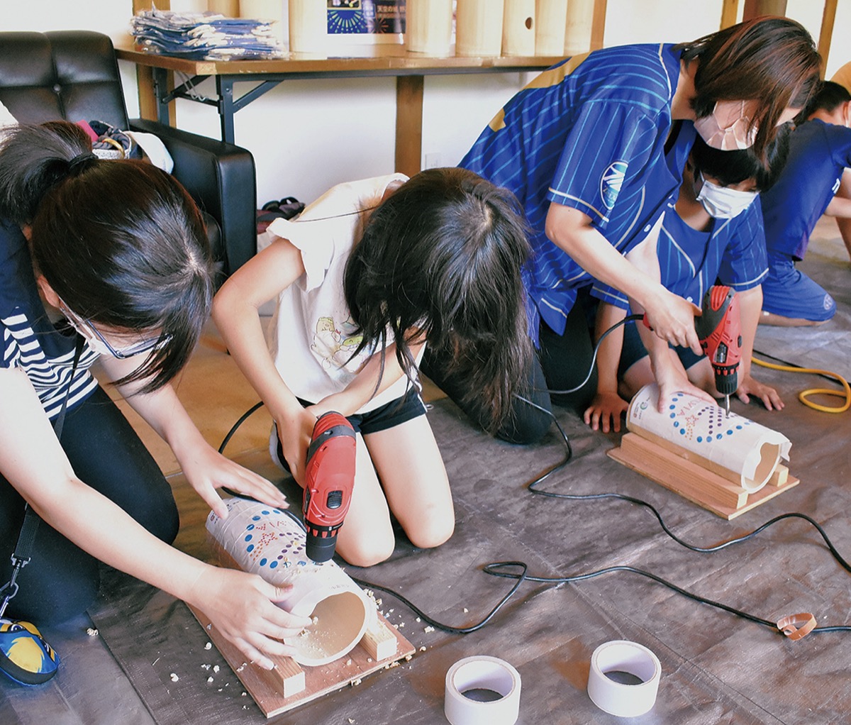 電動ドリルで竹に穴をあける参加者ら