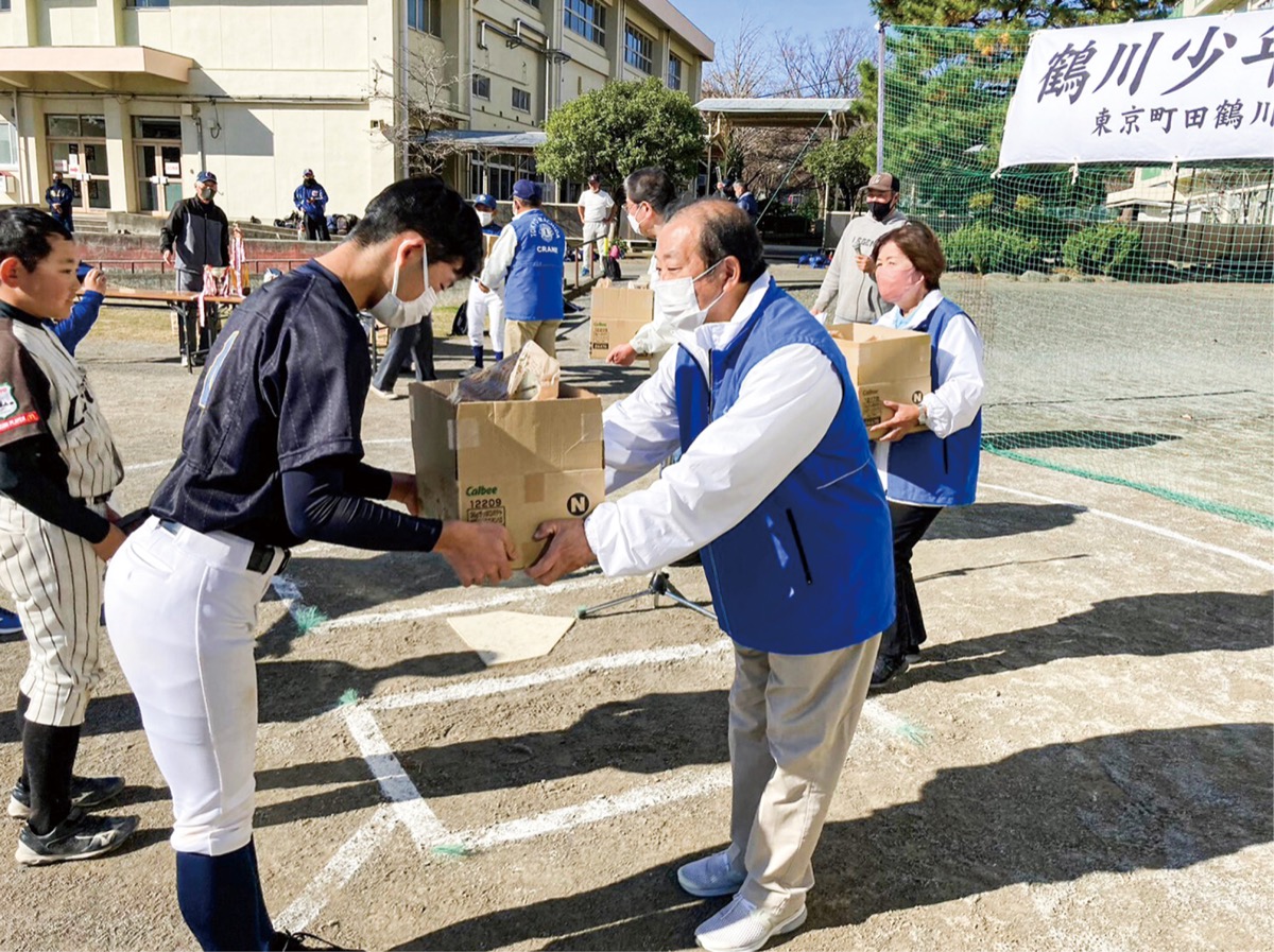 菓子を手渡す高橋会長(手前右)
