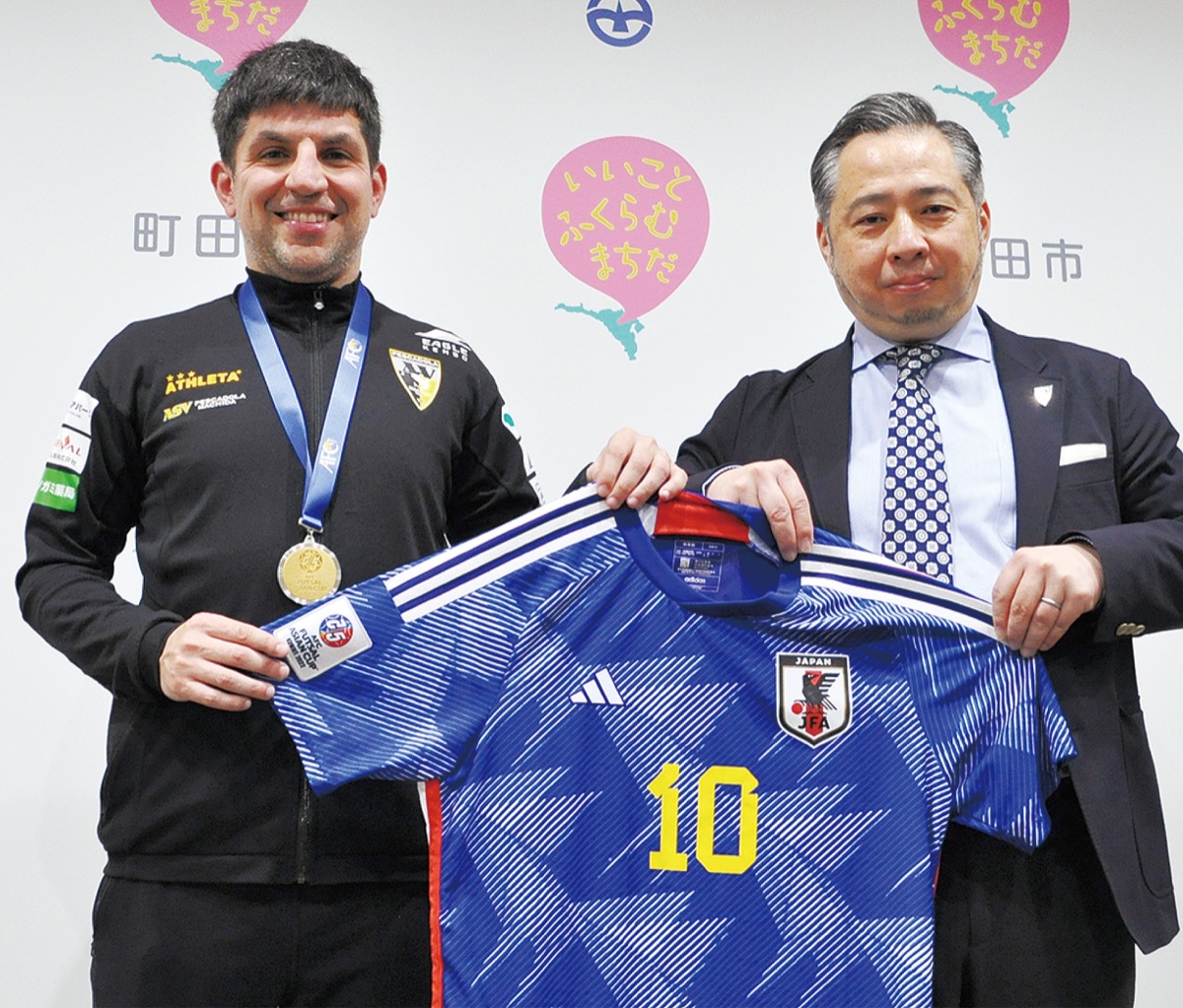 日本代表ユニフォームを手にするヴィニシウス選手(左)と関野社長