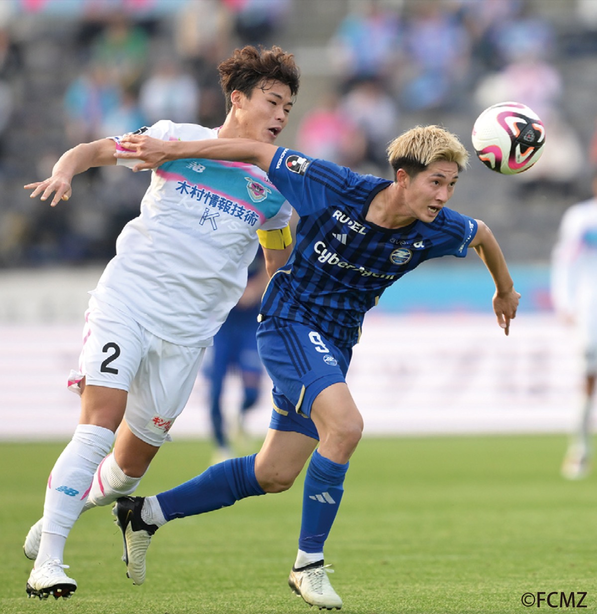 先月の試合で相手選手と競り合う藤尾選手(右)