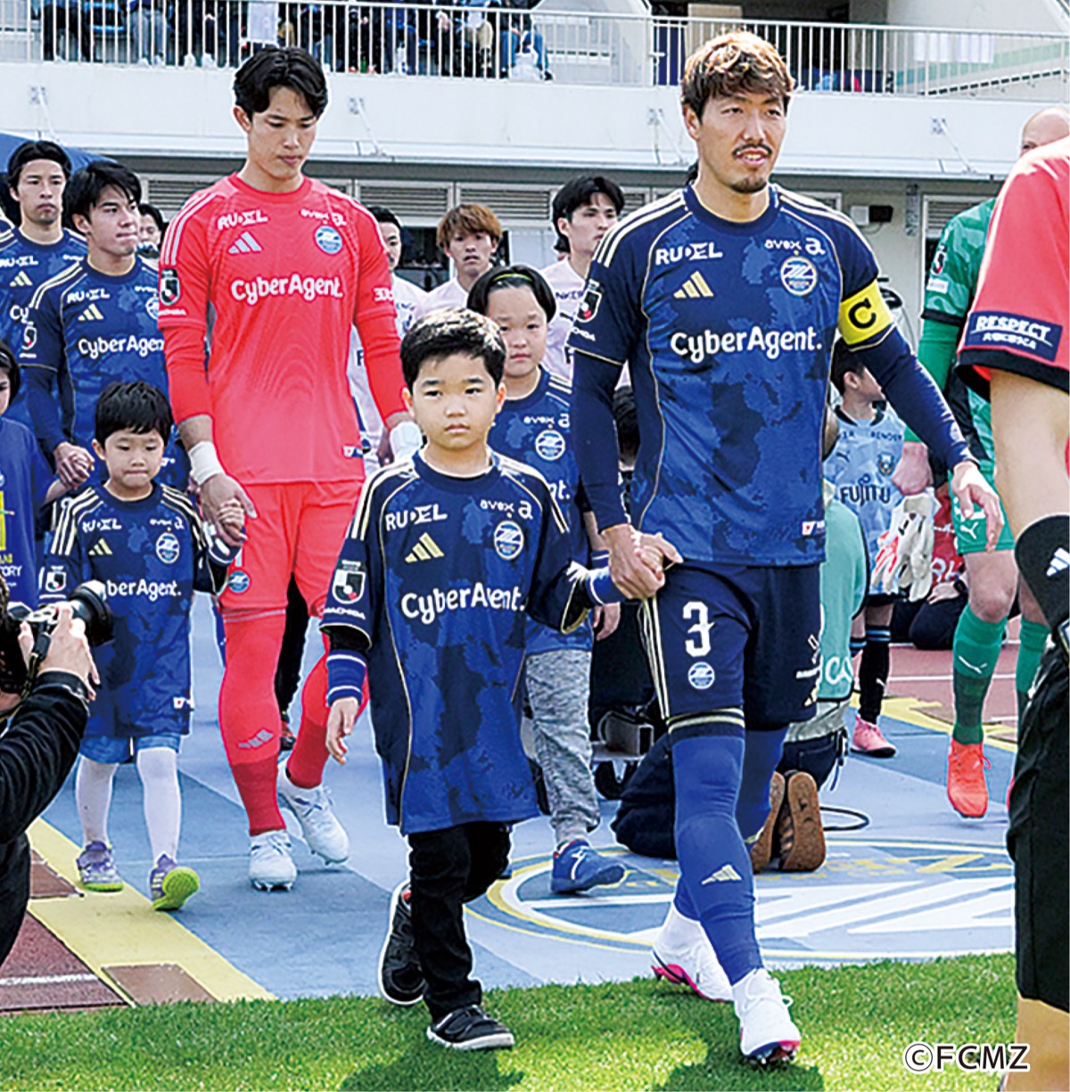 昌子選手と入場するサク君（中央）