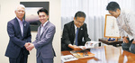 【右】作品の写真を見る石森市長（左）と伊藤さん／【左】八王子商工会議所も訪問。田辺隆一郎会頭（左）に報告した