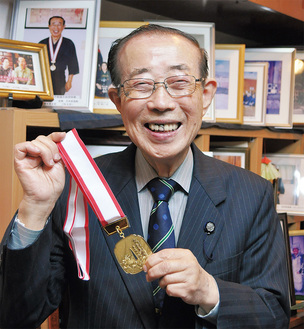 金メダルを手に満面の笑みを浮かべる竹松さん