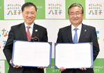 協定を締結した、日本郵便（株）の立林理東京支社長（左）と石森孝志八王子市長