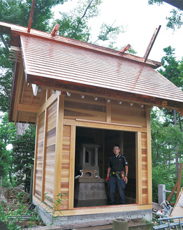 新築された浅間神社の本殿＝13日撮影。中に立つのは森上さん