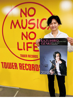 アルバムのポスターを持つ尾崎さん＝提供写真