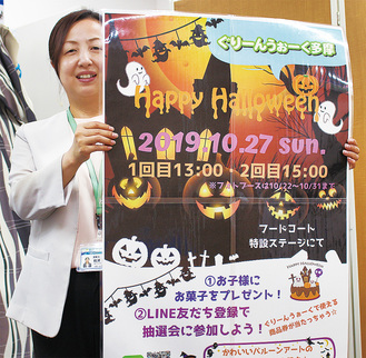 イベントのポスターを掲げる松浦支配人