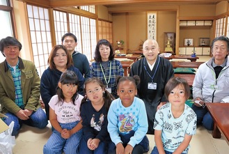 本立寺で過ごす子どもたちと見守りスタッフら。奥の右から２番目が及川住職