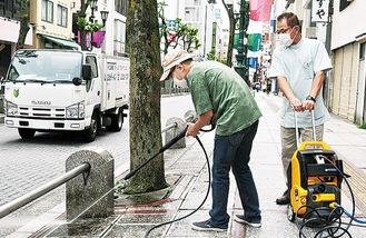 通りを清掃する会員。右は橋本会長