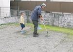 フンを掃除する田所さん（右）とヤギを見に来た子ども