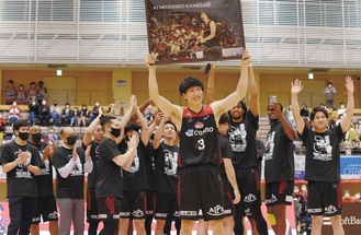 引退セレモニーで仲間に囲まれ、記念パネルを掲げる亀崎選手