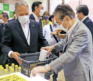 説明する鈴木さん(左)と地酒を手に取る石森市長