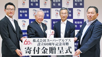 鈴木会長(左から２人目)に寄付金を手渡す同社の社員ら