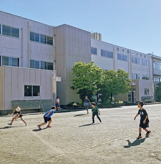 朝早く開門した校庭でドッジボールをする児童たち＝由井第一小、５月24日