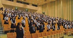 講堂で、式典の中継に合わせて黙とうする生徒ら