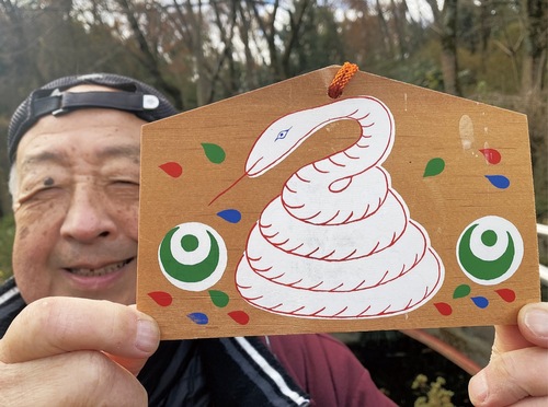 打越弁財天名物・白ヘビの絵馬を手にする保存会の小山会長