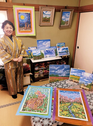 今まで手がけたちぎり絵や油絵作品を紹介する青木さん＝青木さんの自宅にて