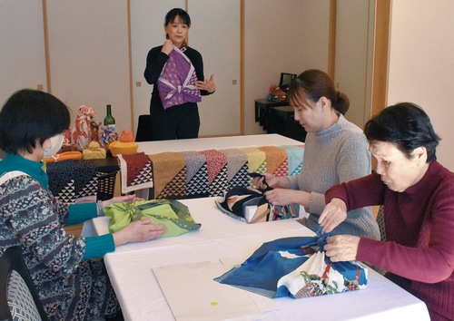 色鮮やかな風呂敷で贈答品の包み方を実践する参加者ら