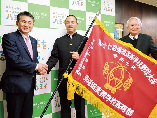 左から初宿市長、センバツ旗を手にした中村主将、和泉監督