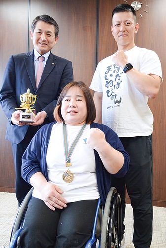 初宿市長（左）に大会の結果を報告した田中さん（中央）と長田トレーナー＝４月４日・本庁舎応接室