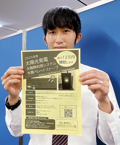 申請概要冊子を手にする担当課職員