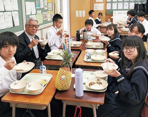 パイナップルコンポートを食す黒須理事長（左から２番目）と生徒たち