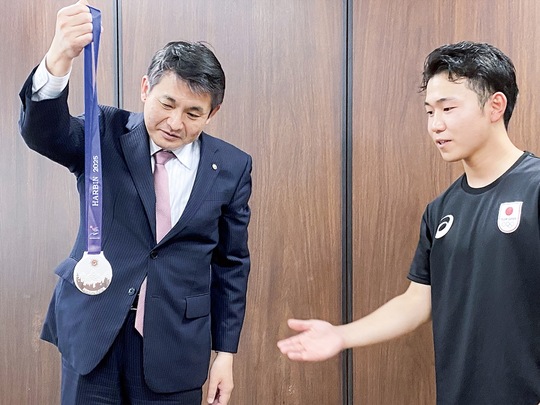 初宿市長（左）に獲得した銀メダルについて説明する菊地原選手