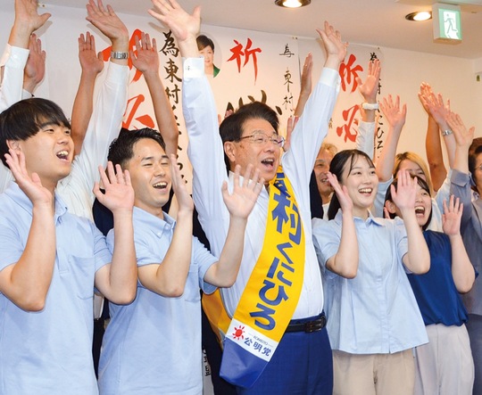 トップ当選し、支援者と万歳で喜ぶ東村氏（中央）
