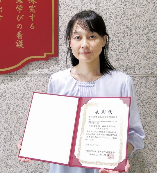 表彰状を手にする斉藤助教＝同大提供