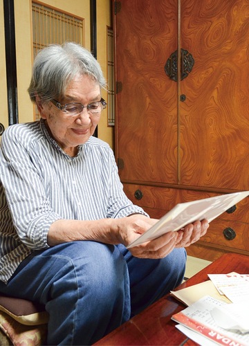 当時の写真を眺める石井さん