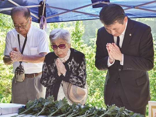 慰霊碑に手を合わせる（左から）齊藤会長、黒柳会長、初宿市長