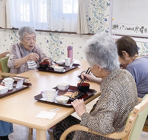 昼食の寿司をほおばる入居者たち