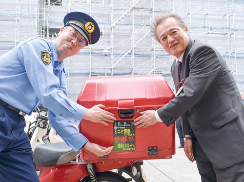 バイクにステッカーを貼り付ける堀口署長（左）と土屋局長