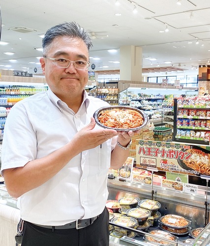 人気の「はちナポ」を手にする惣菜バイヤーの佐藤さん
