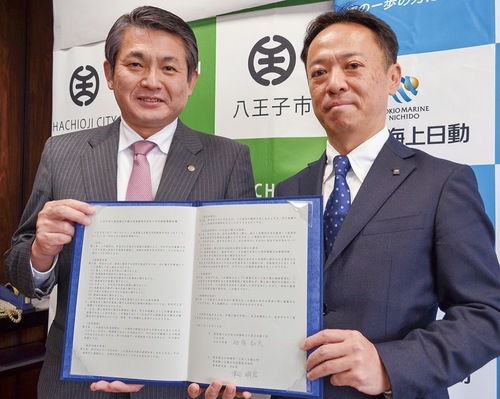 協定書を手にする初宿市長（左）と津田支店長