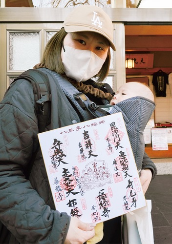 全寺院の御朱印を集めた色紙を手にする母子