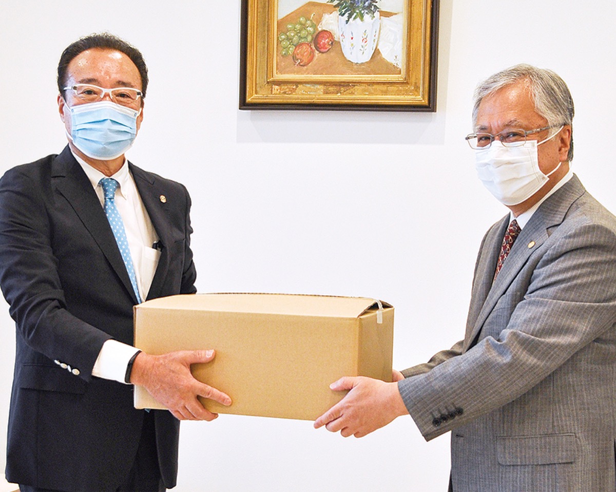 石塚会長＝右＝へマスクを手渡す東ＲＣ平塚会長