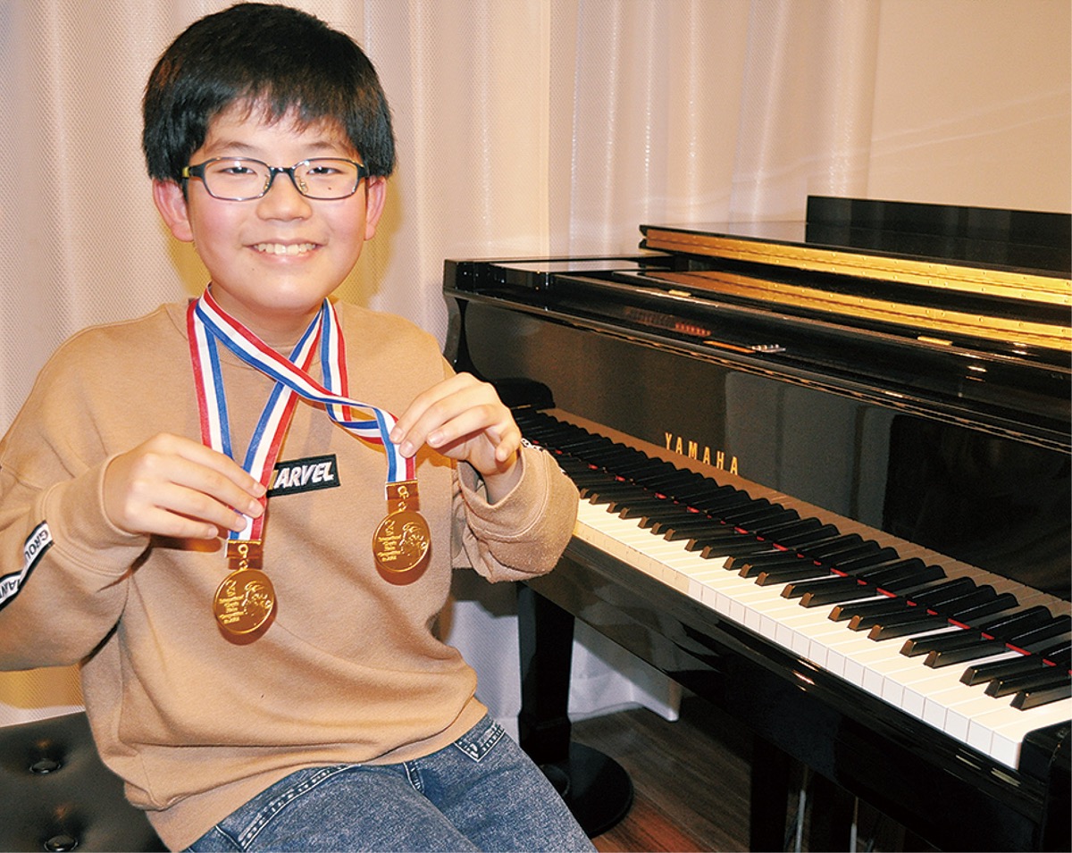 2つの金メダルを持ち喜ぶ小石君