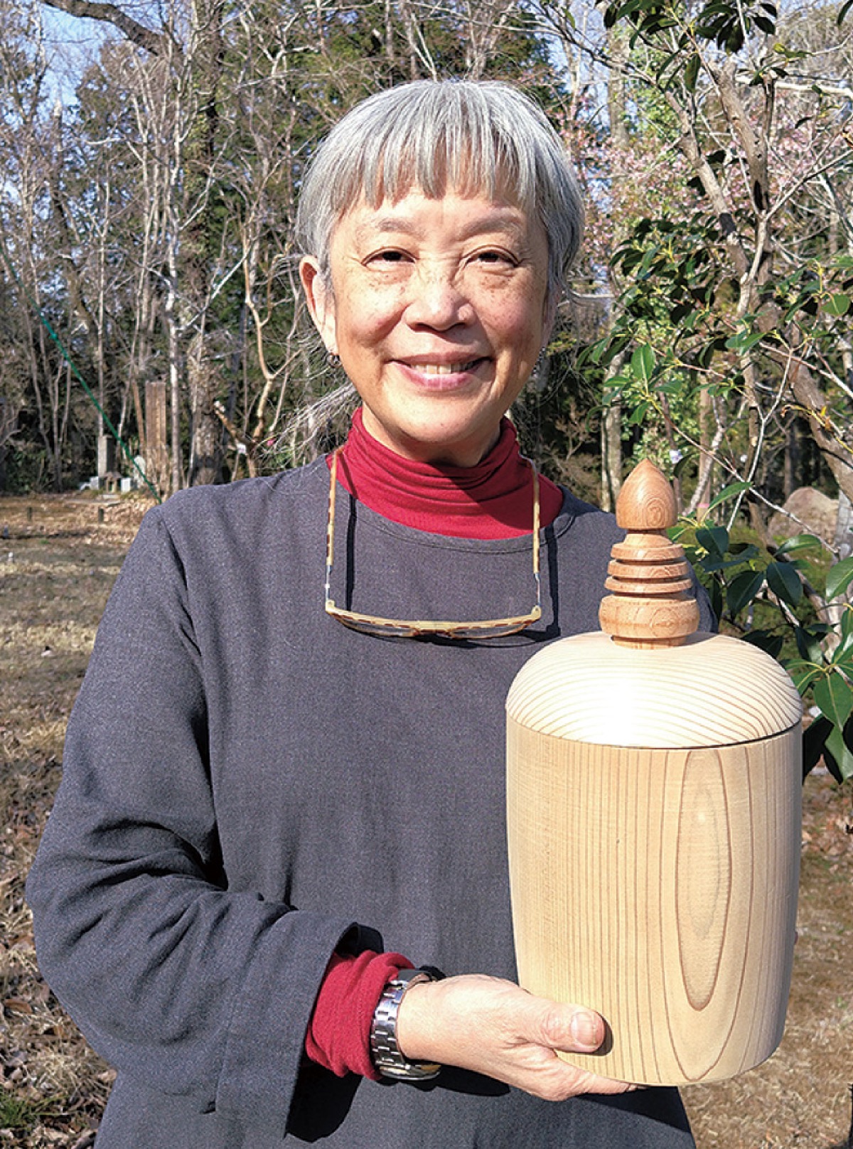 木製の骨壺を手にする中山さん