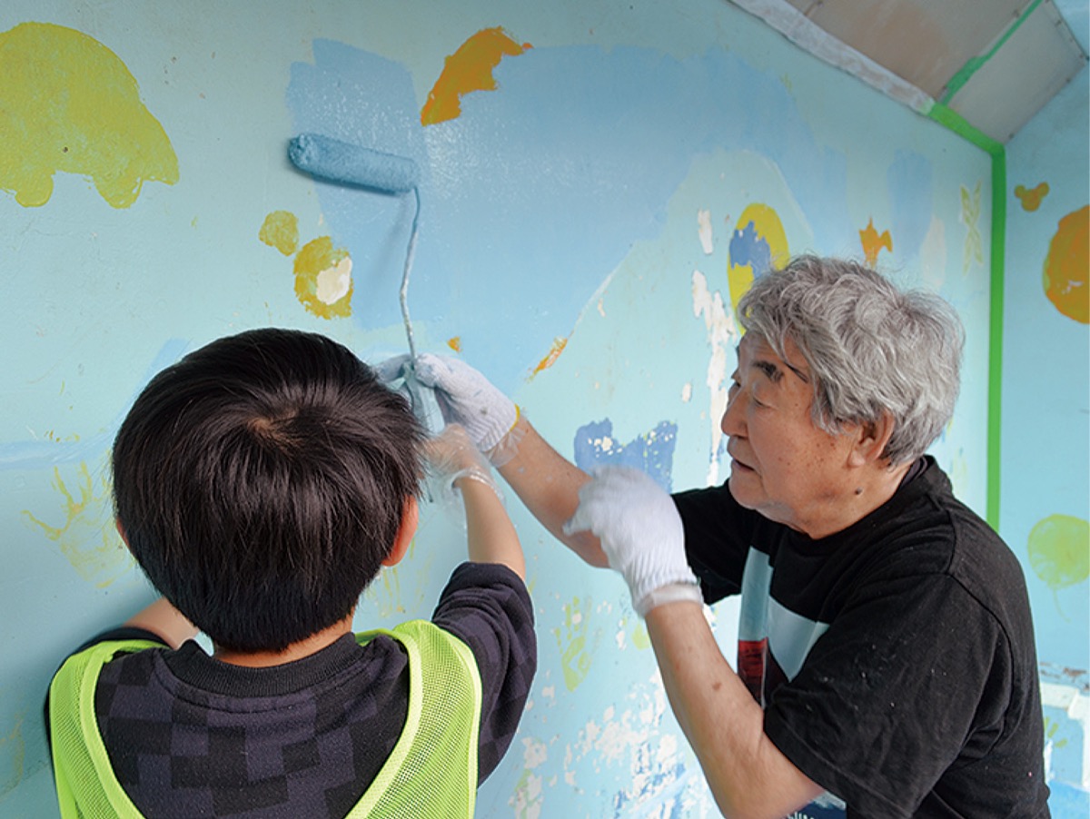 参加児童にペンキの塗り方を指導する銭湯絵師の中島盛夫さん（右）