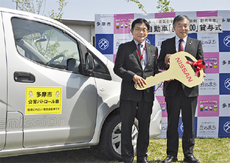 日産自動車販売（株）の加藤彰常務取締役から車を受け取る阿部市長