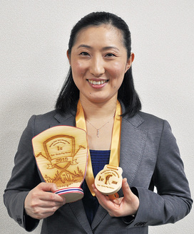 優勝のメダルとトロフィーを手に喜ぶ越村さん