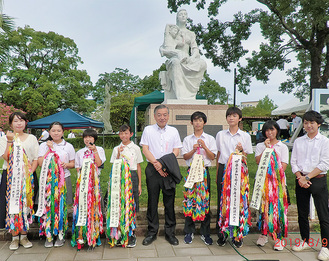 阿部市長と東京純心大学の学生サポーターと平和祈念式典に参列し、千羽鶴を献納した＝多摩市提供